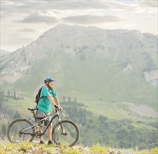 Caucasian man standing with mountain bike