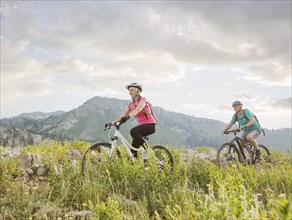 Caucasian couple riding mountain bikes