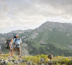 Caucasian grandfather and granddaughter hiking on mountain