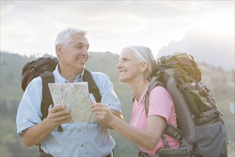 Caucasian couple hiking with map on mountain