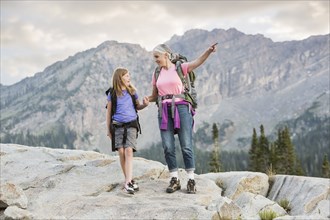 Caucasian grandmother and granddaughter hiking on mountain