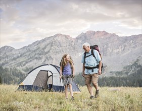 Caucasian grandfather and granddaughter camping on mountain