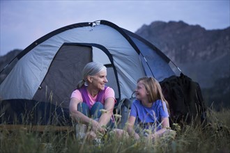 Caucasian grandmother and granddaughter camping on mountain