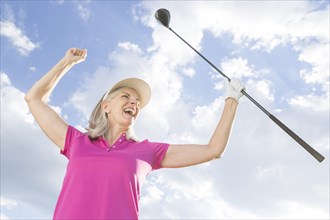 Caucasian woman celebrating with golf club