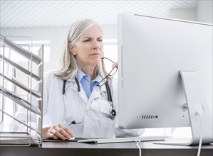 Caucasian doctor using computer at desk