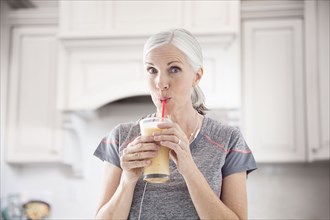Caucasian women drinking smoothie with straw