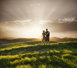 Couple hugging on hill at sunset