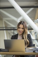 Serious Mixed Race businesswoman using laptop