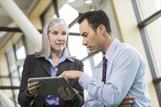 Curious business people using digital tablet