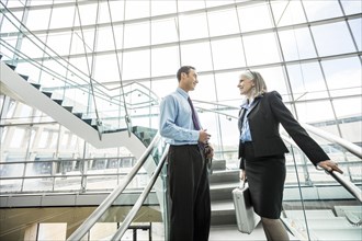 Business people standing on staircase and talking