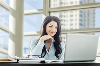 Caucasian businesswoman using laptop
