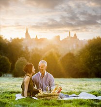 Caucasian couple enjoying a picnic in grass