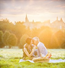 Caucasian couple enjoying picnic in grass