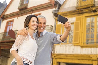 Caucasian couple posing for cell phone selfie