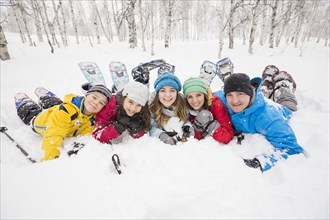 Portrait of smiling Caucasian family laying in snow