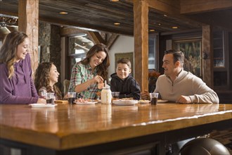 Smiling Caucasian family eating meal at table