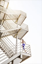 Caucasian woman running on urban staircase