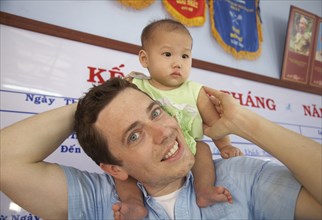 Father carrying baby on shoulders