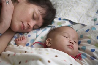 Mother sleeping with baby girl