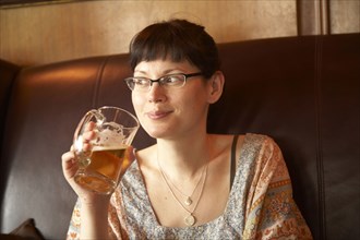 Mixed race woman drinking beer