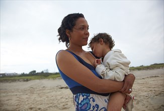 Mother holding son on beach