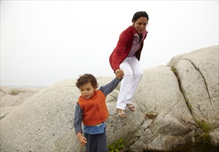 Mother and son climbing on rocks
