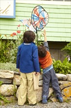 Mixed race brothers playing with pinwheel