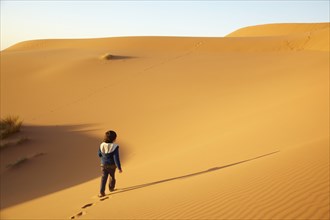 Mixed race boy walking in desert