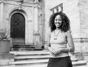 Mixed race woman smiling by church