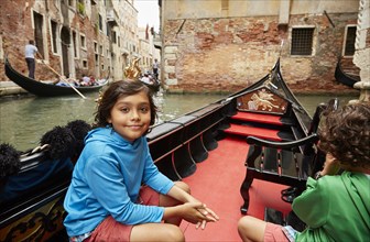 Boy sitting in gondola on Venice canal
