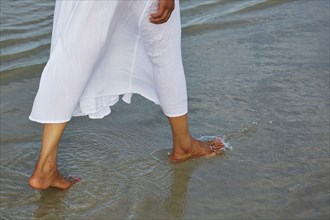 Woman wading barefoot in ocean