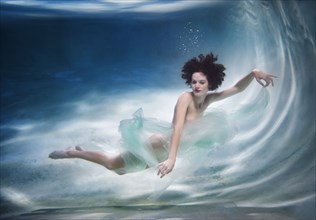 Mixed race woman swimming underwater