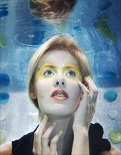 Caucasian woman with makeup on under water
