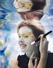 Caucasian putting makeup on under water