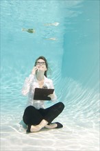 Caucasian businesswoman sitting underwater