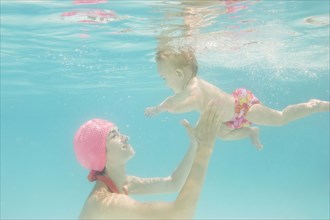Caucasian baby swimming underwater