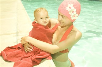 Caucasian mother and baby at poolside