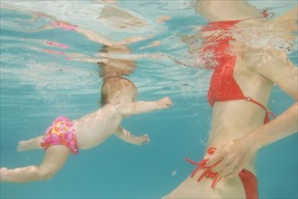 Caucasian baby swimming underwater