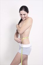 Caucasian woman measuring waist