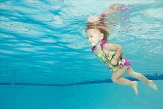 Underwater view of Caucasian girl swimming in pool