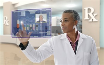 Black doctor using digital display in pharmacy