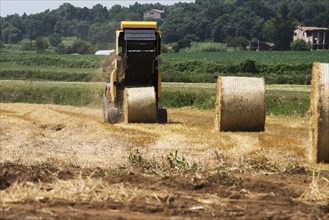 Tractor baling hay in field