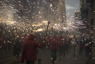 Crowd carrying torches with sparks in parade at night