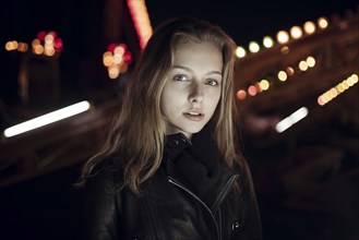 Caucasian teenage girl wearing leather jacket at night
