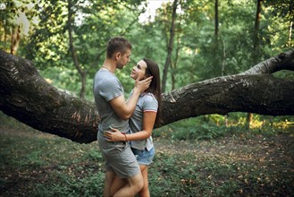 Caucasian couple hugging near tree branch