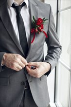 Caucasian man wearing corsage fasting suit jacket button