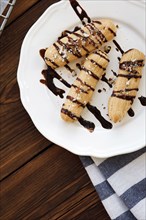 Chocolate syrup drizzled on pastries on plate