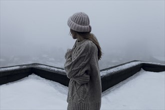 Caucasian woman standing on rooftop in winter