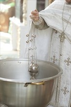 Priest holding chalice in bowl
