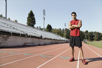 Male athlete posing for the camera on a track